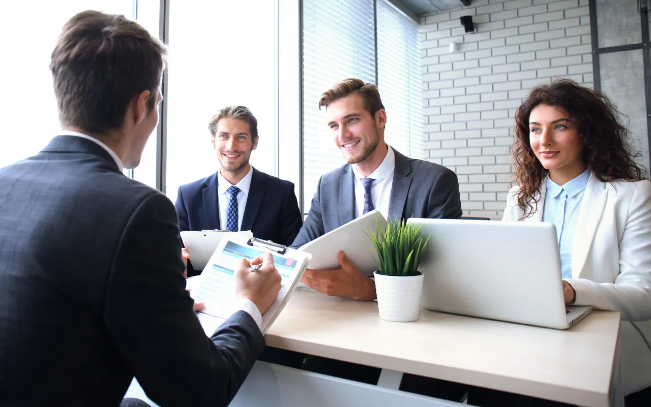 Diverse claims specialists collaborating over statistics to find the best talent-employer matches